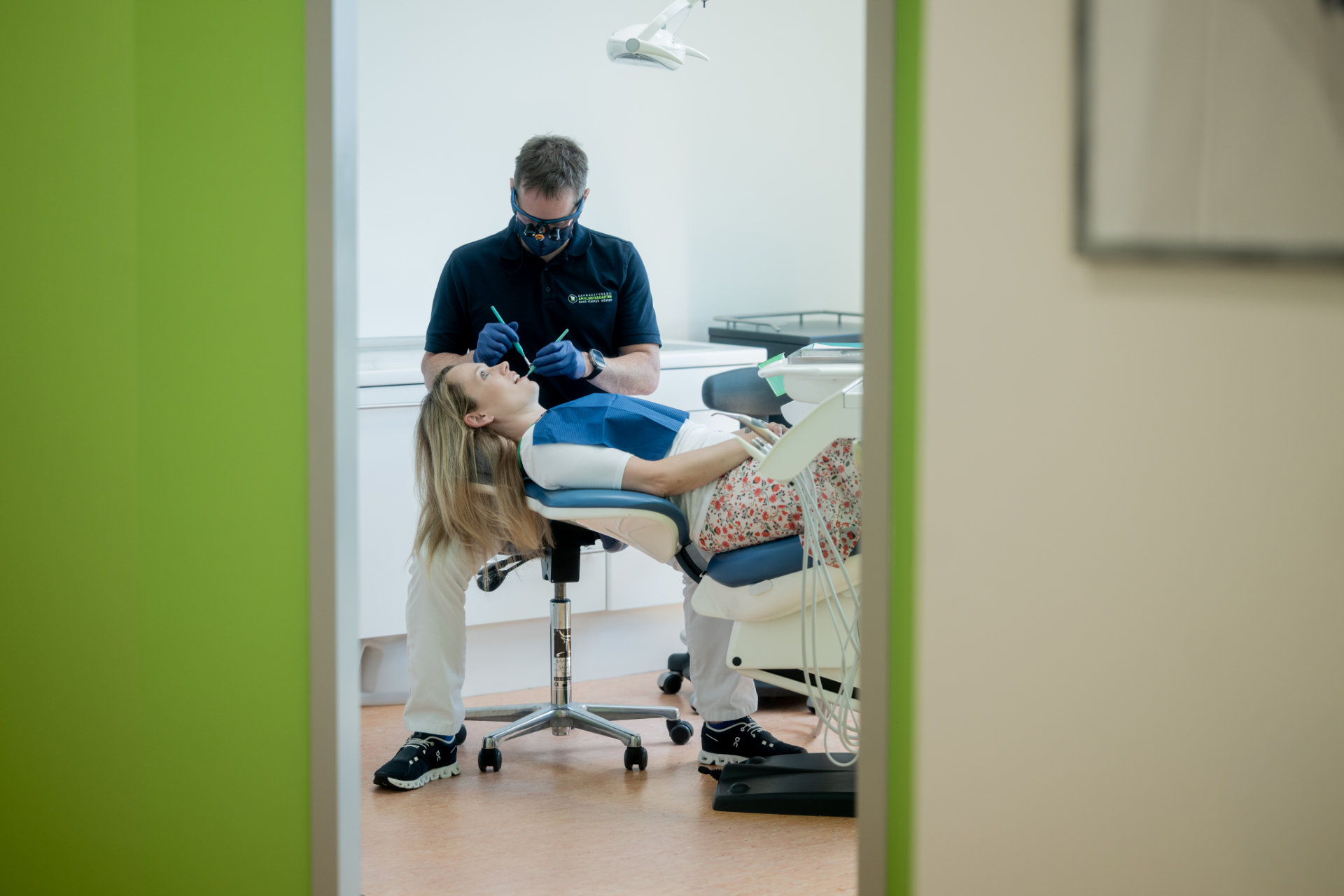 Blick durch die Tür in ein Behandlungszimmer während einer Zahnbehandlung